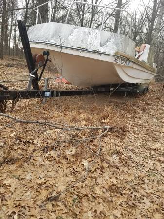 Boat that needs work and Tandem trailer plus part of an engine